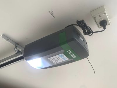 Close-up of a Merlin Garage Door Opener installed in an Australian garage, showcasing its sleek design and modern features like the myQ smartphone control system.